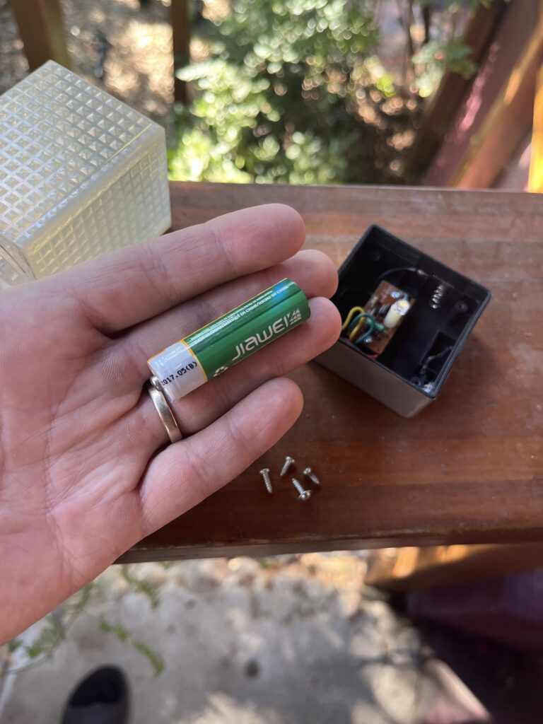 hand holding NiCad rechargeable battery from a solar light